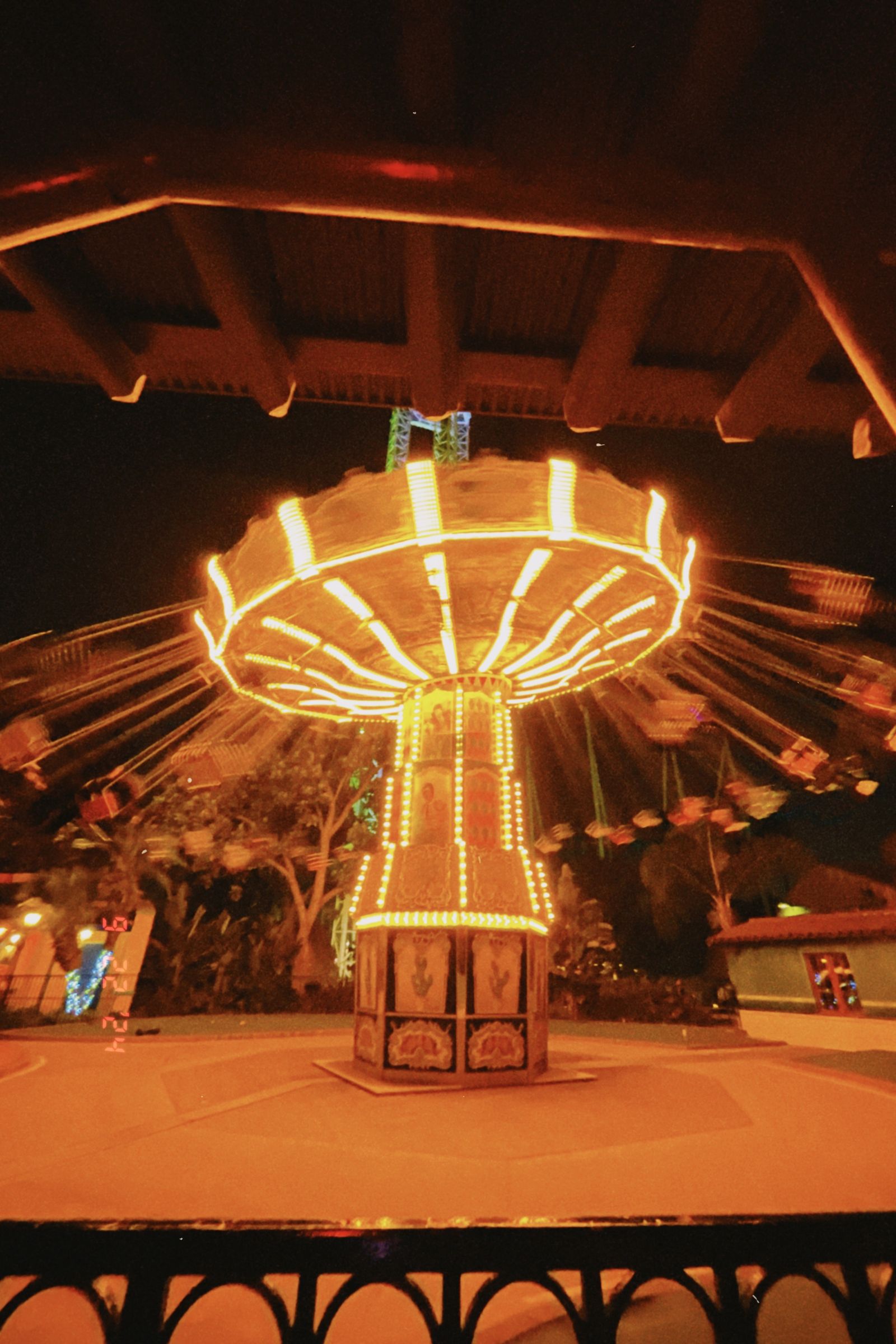 Brightly lit carousel spinning at night in an amusement park