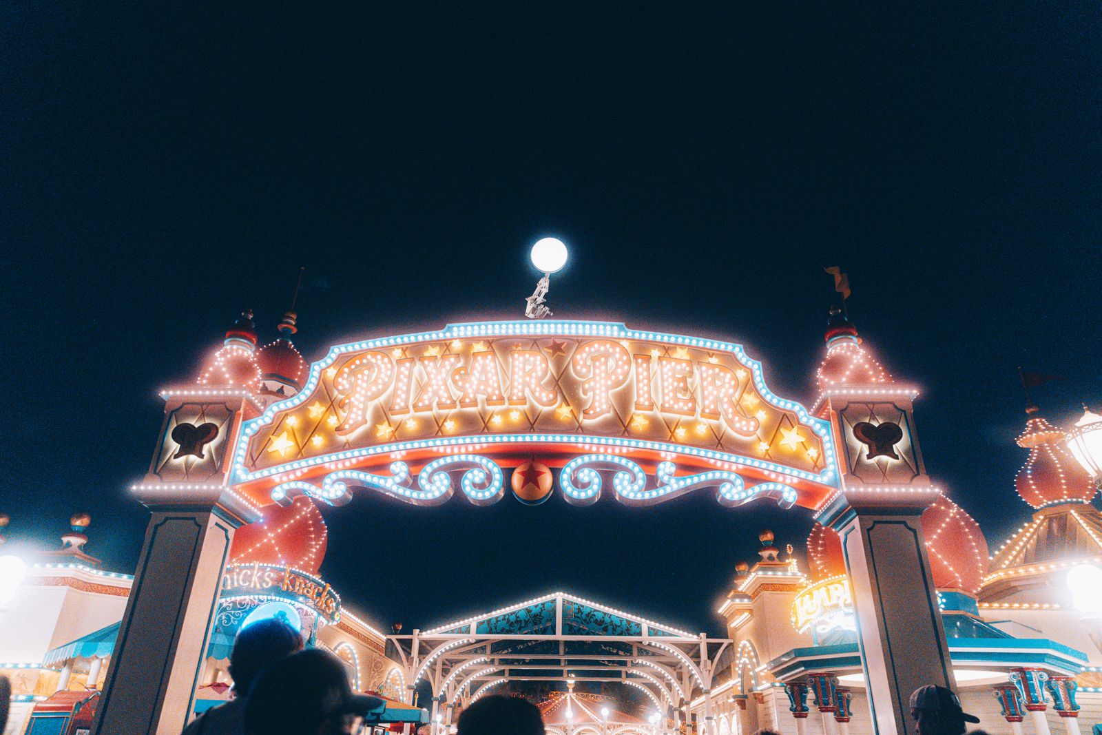 Illuminated Pixar Pier entrance arch at night at the Disneyland Resort in Anaheim