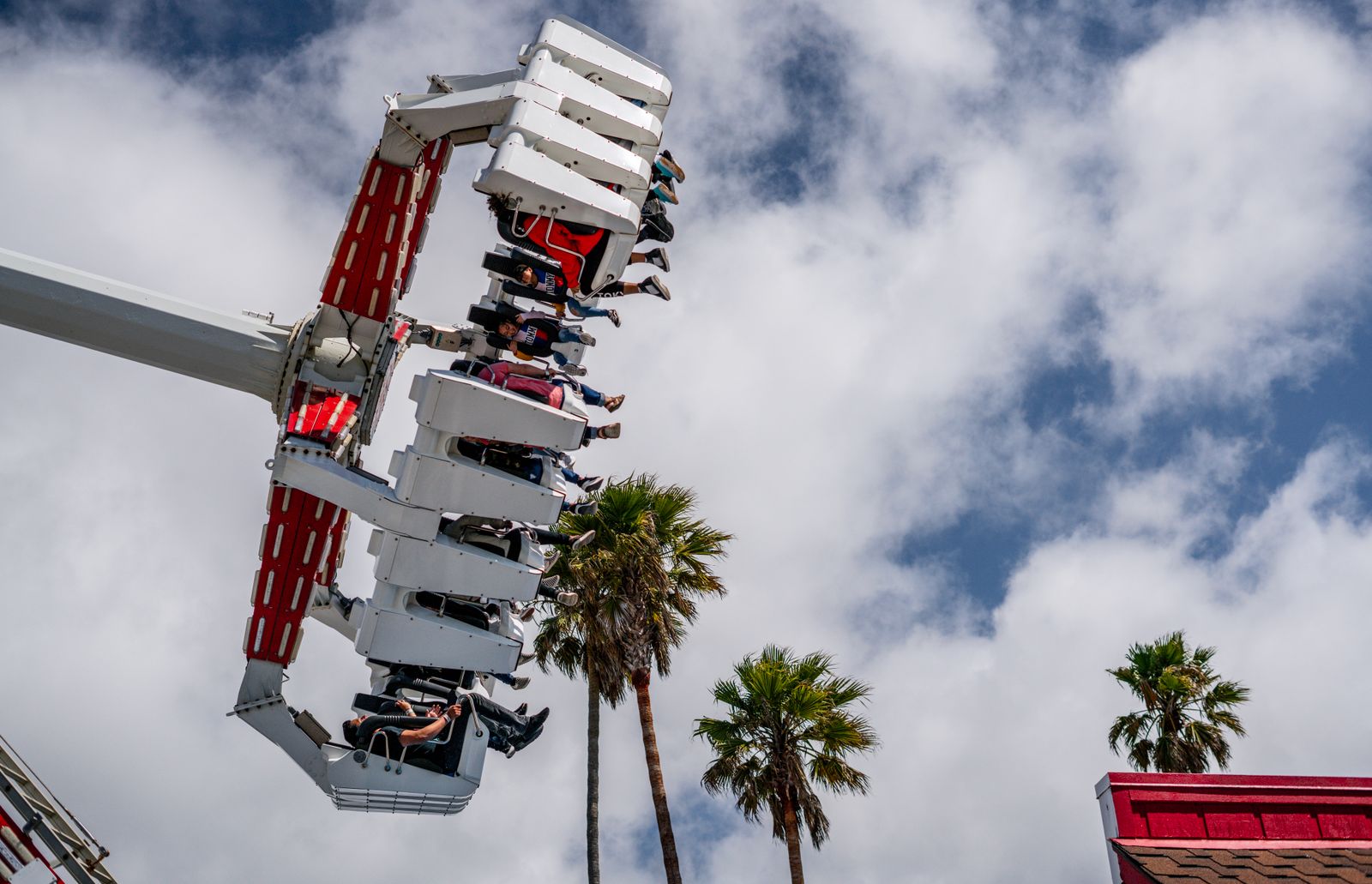Low angle view of spinning theme park rides on a sunny afternoon