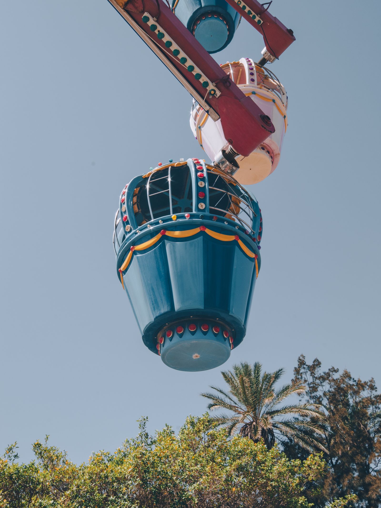 Ferris wheel gondola against a clear blue sky at a Southern California theme park